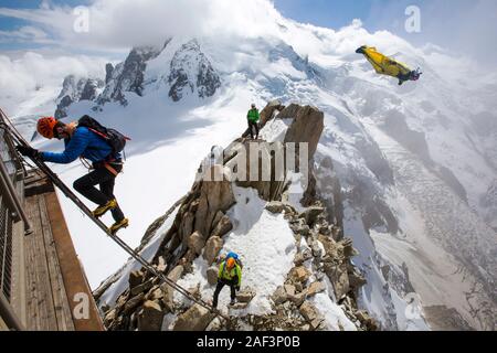 Mont Blanc dall'Aiguille du Midi al di sopra di Chamonix, Francia, con gli alpinisti sul Cosmétiques Arete, salendo la scala per accedere alla stazione della funivia Foto Stock