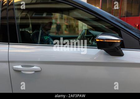 Uomo alla guida di un'auto nel centro della città Foto Stock