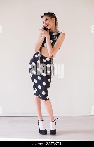 Ritratto di una bella donna alla moda con trecce in un nero polka dot dress Foto Stock