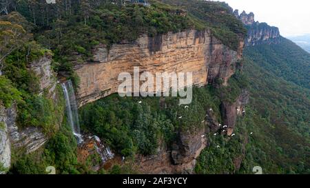 Una cascata nelle Blue Mountains ad ovest di Sydney, Nuovo Galles del Sud, Australia. Guardando verso le tre sorelle rock landmark. Foto Stock