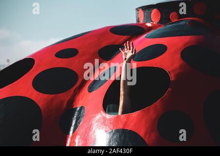 Maschio lato turistico fuori del 'Akakabocha' (rossa zucca), Yayaoi Kusama arte installazione presso Miyanoura Porto di Naoshima Island. Foto Stock