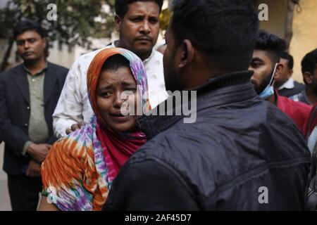 Dacca in Bangladesh. Xiii Dec, 2019. Un parente di una vittima morta da una fabbrica di plastica fire reagisce all'interno di Dhaka Medical College Hospital morgue. Secondo la relazione di media, almeno 13 lavoratori sono stati uccisi e 20 feriti mercoledì in un incendio dopo una bombola di gas esplosione in una fabbrica di plastica vicino Keraniganje area. Credito: MD Mehedi Hasan/ZUMA filo/Alamy Live News Foto Stock