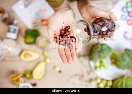 Azienda essiccato rosa canina al tavolo con un sano vegan ingredienti alimentari e supplementi, vista dall'alto. Concetto di rosa canina come una nuova tendenza nel cibo e industria cosmetica Foto Stock