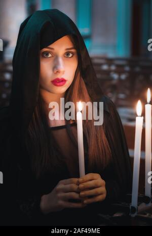 La donna nella Chiesa con candela accesa Foto Stock