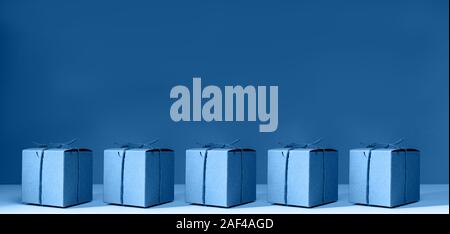 Imbarcazioni di cartone scatole regalo sul solido classico sfondo blu. Vacanza e concetto di regalo. La Pop art slyle. Orizzontale, wide screen formato banner Foto Stock