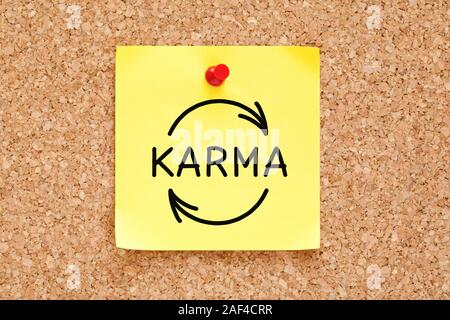 Disegno a mano il Karma il concetto di ciclo su adesivo giallo nota appuntata sul sughero bulletin board. Foto Stock