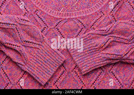 Donna felpa lavorata a maglia con arana. Di un bel colore rosa autunno lana maglione con maniche lunghe. Vista frontale. Foto Stock