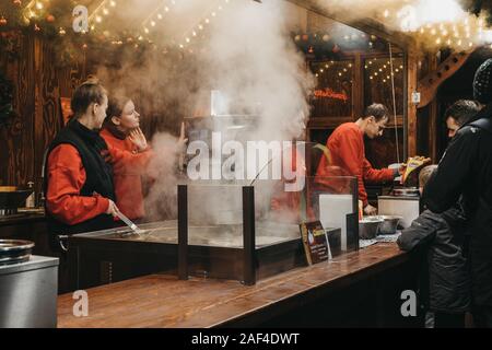 London, Regno Unito - 24 Novembre 2019: la gente lavora in stallo churros al mercatino di Natale a Trafalgar Square a Londra. Churros sono un tradizionale snack da Foto Stock