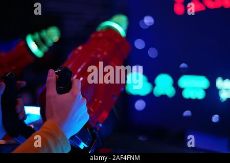 In prossimità di uno mani giocando in una macchina di gioco in un Arcade entertainment center. Concetto di centro di Arcade. Foto Stock