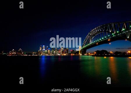 Sydney Harbour Bridge e la Opera House di notte, da Jeffrey Street fermata di traghetto a Milsons Point sulla sponda nord, Sydney, Australia Foto Stock