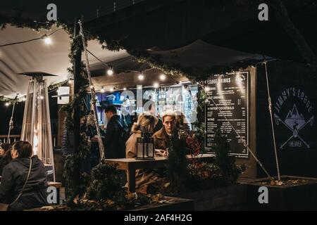 London, Regno Unito - 24 Novembre 2019: la gente in un bar nel centro di Southbank mercato invernale, una piscina esterna, global street market alimentare, incentrata sulla sostenibilità di un Foto Stock