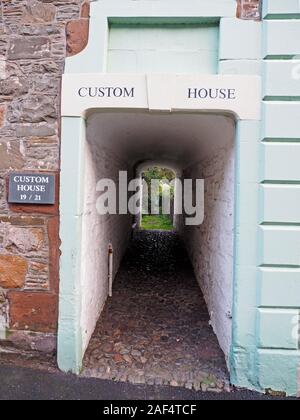 In acciottolato bianco-verniciato vicoletto da street con segno Custom House al di sopra di ingresso ad arco a Kirkcudbright, Dumfries & Galloway, Scotland, Regno Unito Foto Stock