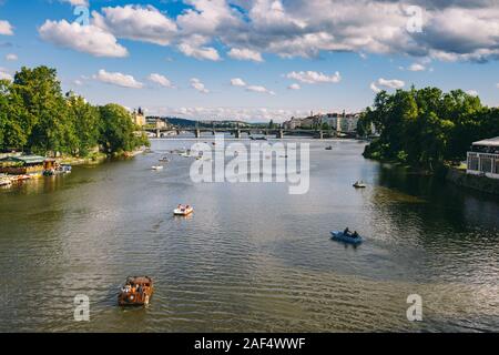 Panorama di Praga, un sacco di catamarano galleggia sul fiume. Catamarani con turisti di appoggio galleggiante sul fiume presso il Ponte Carlo, in Foto Stock