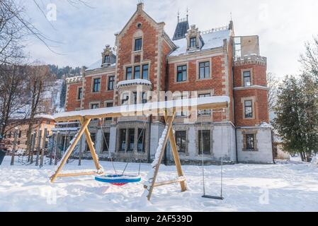 Parco giochi per bambini in municipio in inverno, coperta di neve park, al centro della citta'. Schladming, Austria Foto Stock