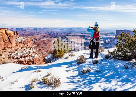 Una donna di scattare le foto della vista spettacolare, Island in the Sky, il Parco Nazionale di Canyonlands, Utah, Stati Uniti d'America. Foto Stock