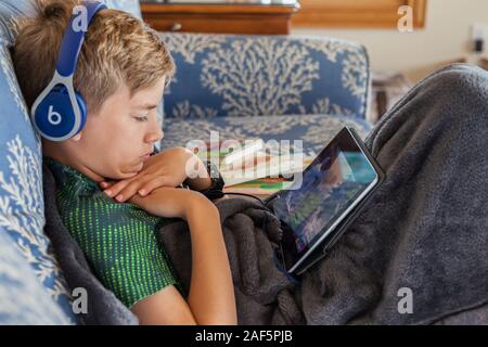 Undici-anno-vecchio ragazzo e il suo iPad. Avon, Outer Banks, North Carolina. (Modello rilasciato) Foto Stock