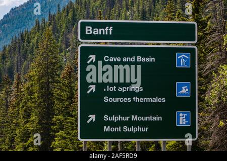 Canadian due lingue francese e inglese le informazioni stradali segnaletica verde, città di Banff, grotta e bacino, hot springs, montagna di zolfo, Alberta, Canada Foto Stock