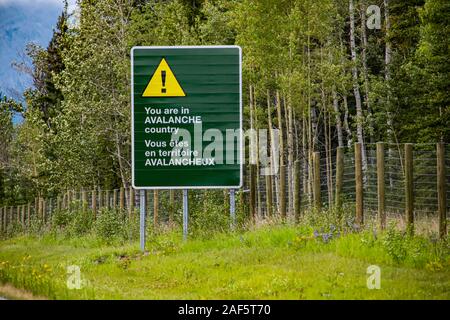 Due lingue francese e inglese informazioni road bilingue segno verde sulla strada, siete nel paese a valanga con il triangolo di avvertenza giallo simbolo Foto Stock