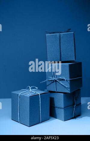 Artigianato scatole di cartone sul solido classico sfondo blu. Vacanza e concetto di regalo. In verticale Foto Stock
