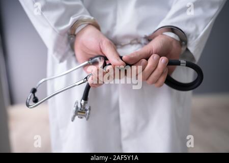 Close-up di dottore le mani con uno stetoscopio in manette Foto Stock