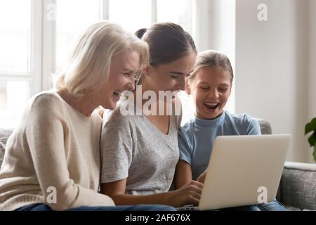 Tre generazioni di donne hanno divertente guardare video sul computer portatile Foto Stock
