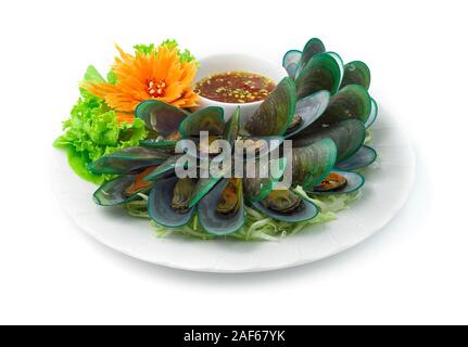 Le cozze al vapore (cozze fresche bollite con basilico tailandese) servita con frutti di mare piccante salsa cibo Thai Style goodtasty decorare con verdure e scolpito C Foto Stock