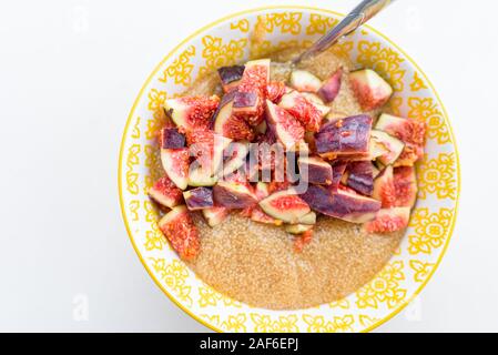 Porridge di amaranto per la prima colazione con i fichi in una ciotola gialla vista superiore Foto Stock