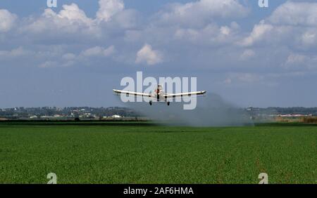 La formazione di polvere di raccolto un aereo spruzzando insetticidi su colture. Fotografato nella valle di Jezreel, Israele Foto Stock