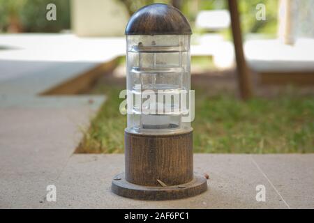 Insieme di lampade in legno su un terreno elevato . piccola lanterna in un giardino sulla terra . Massa illuminazione strada lampada montata su un prato verde in un parco . Foto Stock