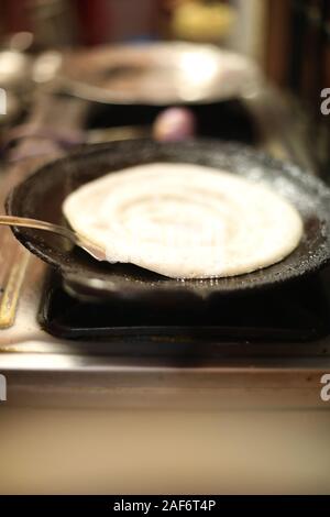 Dosa il cibo indiano. cottura di dosa in cucina, India. Sud indiano vegetariano, Foto Stock