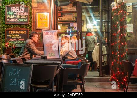 Un uomo e una donna si siedono al di fuori di un cafe in una posizione romantica a Madrid, Spagna. Foto Stock