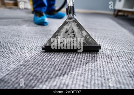 Close-up di un tappeto di pulizia con aspirapolvere Foto Stock