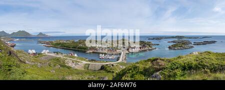 Paesaggio urbano e il paesaggio al circolo polare artico villaggio con porto e ampio ingresso, ripresa dall'alto sotto una luce brillante a Ballstad, Vestvagoya, Lofoten, né Foto Stock