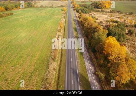 Golden foliadge e verdi campi attorno alla strada, drone foto. La Russia, la regione di Kaliningrad, autostrada Berlinka Foto Stock