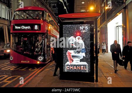 Chanel No. 5 spot di profumo illuminato alla fermata bus shelter e red double decker numero 8 autobus sulle strade della città di Londra Inghilterra KATHY DEWITT Foto Stock