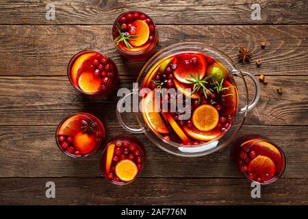 Punzone di natale. Festive red cocktail e drink con mirtilli e agrumi in un punch bowl e bicchieri Foto Stock