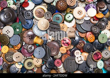 Vista superiore del mucchio di molti diversi pulsanti close up su blu Foto Stock