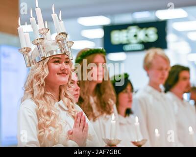 Tradizionale festa di Santa Lucia in Svezia. Norrkoping's Lucia 2019 Izabella Swartz cantando canti natalizi nel centro commerciale di Linden. Foto Stock