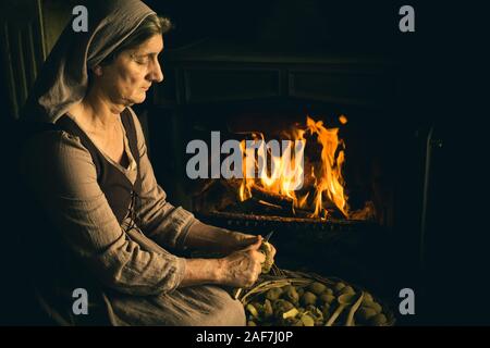 Renaissance master precedente ritratto di una donna contadina pelatura patate al suo caminetto Foto Stock