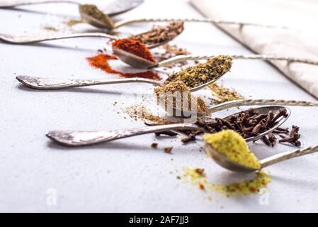 Varie spezie curcuma macinata di pepe cannella zenzero erbe sale di stagionatura paprika semi di cumino sul tavolo. Vista da sopra. fragranti spezie indiane Foto Stock