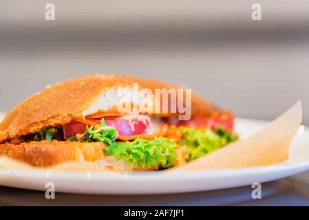 Il fast food concept. Sandwich a caldo sulla piastra di close-up. Messa a fuoco selettiva Foto Stock