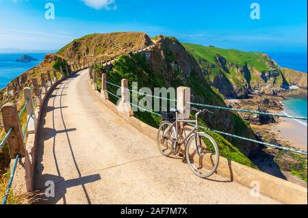 Biciclette parcheggiate in binario su Sark istmo. Sark è una parte delle Isole del Canale nel sudovest della Manica, al largo della costa della Normandia, Foto Stock