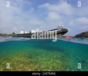 Una barca rigida gonfiabile ormeggiato con due gabbiani, vista suddivisa al di sopra e al di sotto della superficie dell'acqua, mare Mediterraneo, Spagna Cadaques, in Costa Brava Catalogna Foto Stock