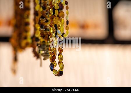 Sfondo di colore ambra di perle e collane al mercato dell'artigianato. Souvenir tradizionali dai paesi baltici, messa a fuoco selettiva - immagine Foto Stock