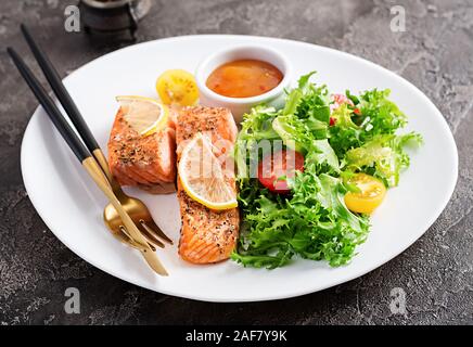 Cotto al forno filetto di salmone con verdure fresche insalate. Cibo sano. Ketogenic/paleo dieta. Foto Stock