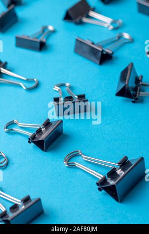 Il legante di fermagli per carta su uno sfondo blu Foto Stock