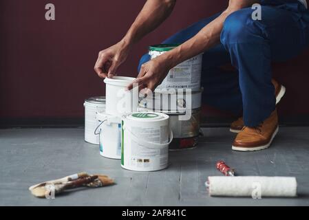 Processo di preparazione. Giovane africana lavoratore americano in uniforme blu hanno alcuni job Foto Stock