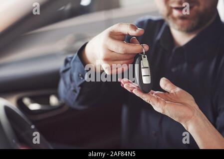 Ho fiducia che voi prendete le mie chiavi. Assistente manager fornendo consigli e aiuto al cliente nel Salon Automobile Foto Stock