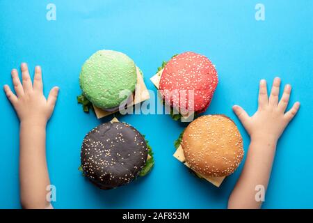 Bambini le mani e il quartiere alla moda di set di multi-colore di piccole hamburger. Foto Stock