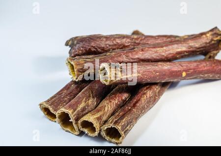 Un gruppo di bastoni di una vacca essiccato esofago. Sano naturale tratta per i cani. Carni bovine esofago su uno sfondo luminoso. Gustose chicche per animali domestici. F selettiva Foto Stock